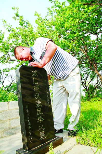 张福正一遍又一遍地擦拭父亲的墓碑。